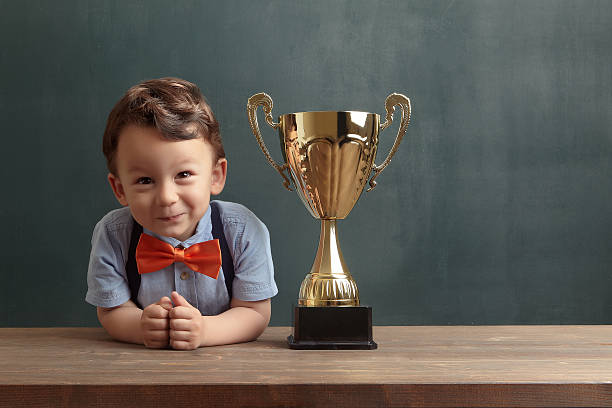 istock Little boy smiling with a golden trophy 485475004
