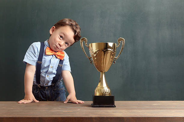 istock Little boy smiling with a golden trophy 485475008