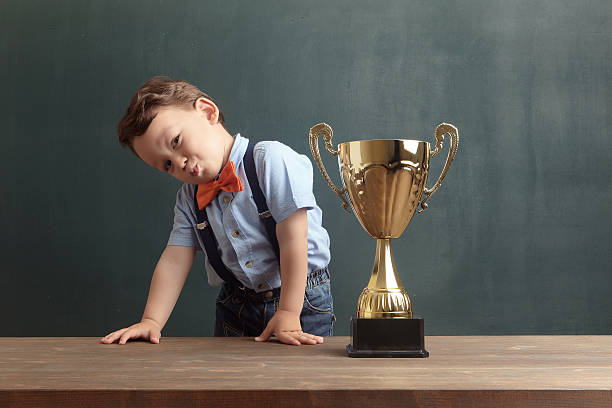 istock Little boy smiling with a golden trophy 485475016
