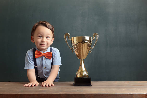 istock Little boy smiling with a golden trophy 485475022