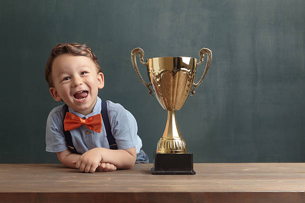 istock Little boy smiling with a golden trophy 485475026