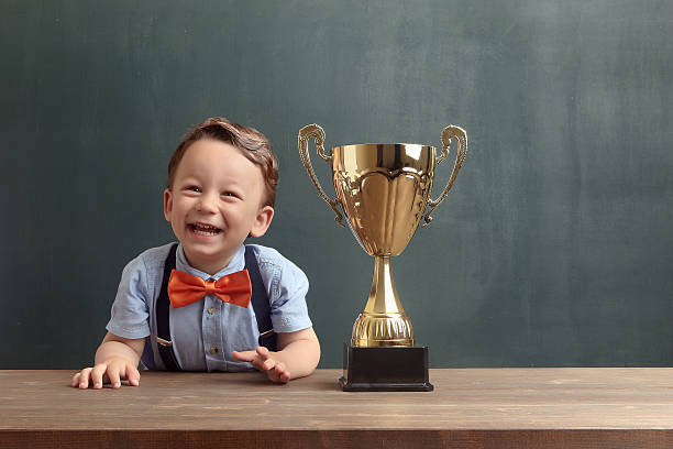 istock Little boy smiling with a golden trophy 485475052