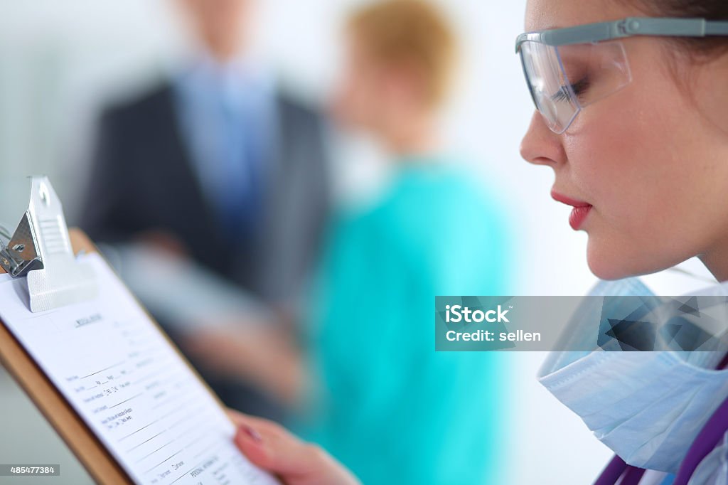 Woman doctor standing with folder at hospital Woman doctor standing with folder at hospital . 2015 Stock Photo