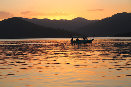 Fishermen's boat turning back home during the sunset in Gocek, Fethiye which is one of the most important sailing centers of Turkey.