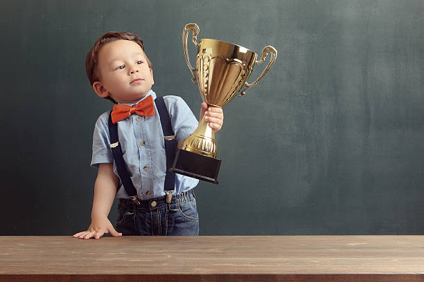 istock Little boy raising a golden trophy 485479164