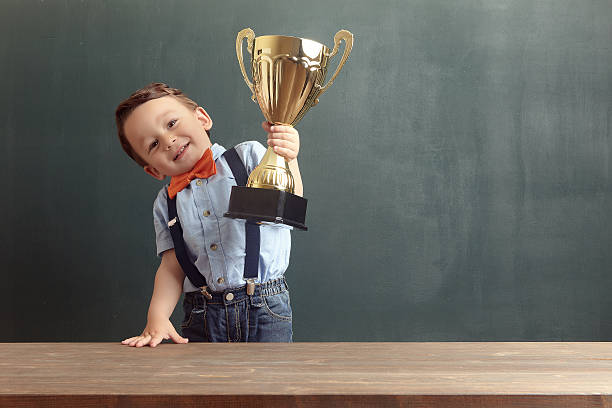 istock Little boy raising a golden trophy 485479172