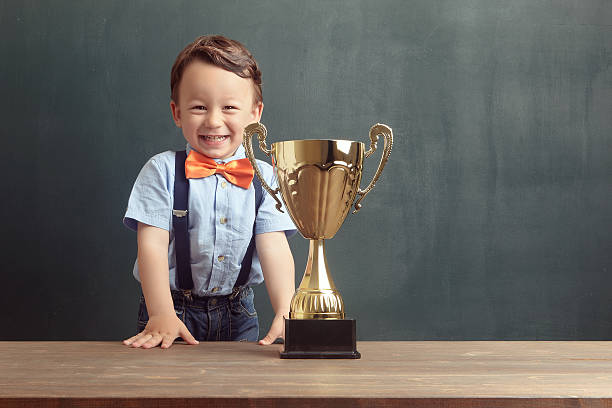 istock Little boy smiling with a golden trophy 485479186