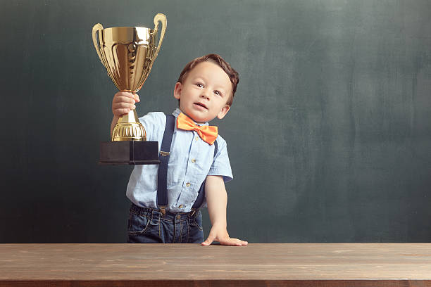 istock Little boy raising a golden trophy 485479194