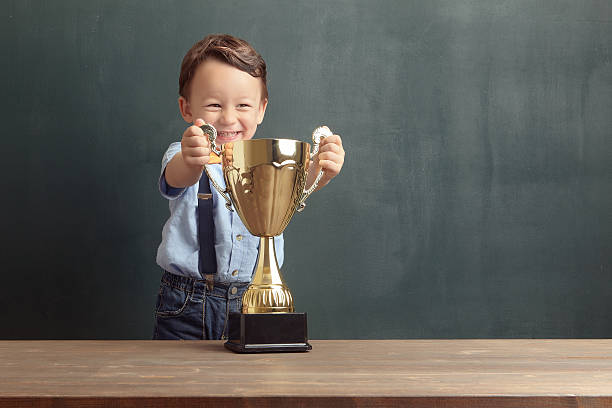 istock Little boy holding a golden trophy 485479204