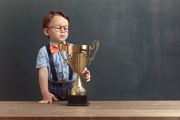 istock Little boy smiling with a golden trophy 485479210