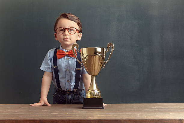 istock Little boy smiling with a golden trophy 485479226