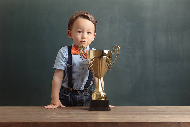 istock Little boy smiling with a golden trophy 485479912