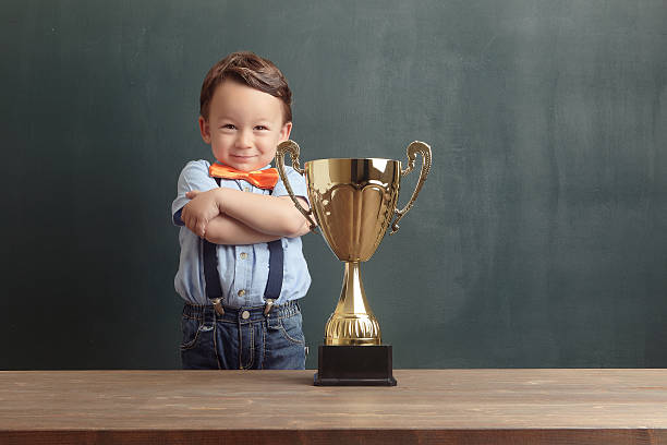 istock Self-confident little boy folding his arms with golden trophy 485480102