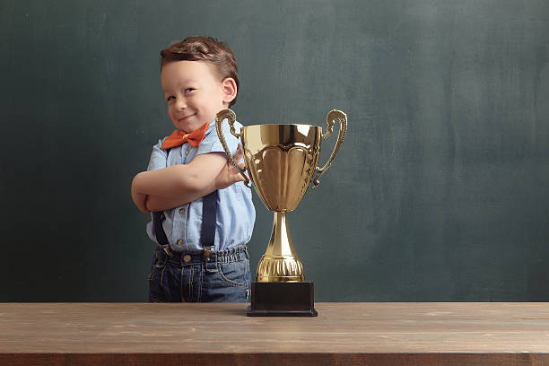 istock Self-confident little boy folding his arms with golden trophy 485480170