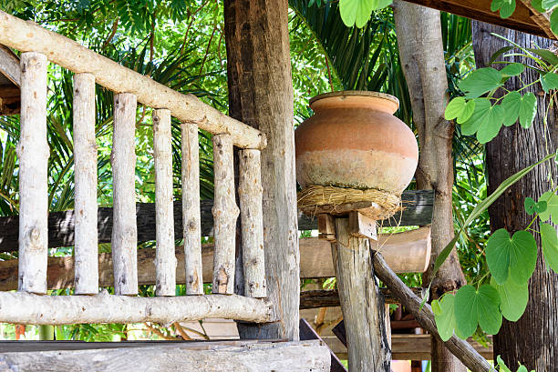 istock Earthen water jar in front of a rustic wooden house. 485481978