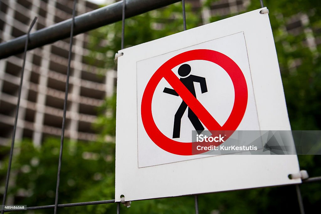 Construction site warning signs No entry sign on the fence in contruction site with house under construction and green trees in the background 2015 Stock Photo