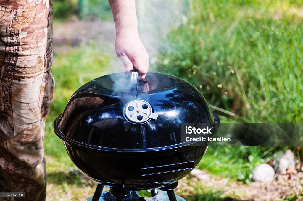 Chef hand holding the lid closed grill Barbecue Grill Stock Photo