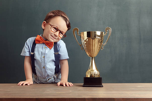 istock Little boy smiling with a golden trophy 485487610