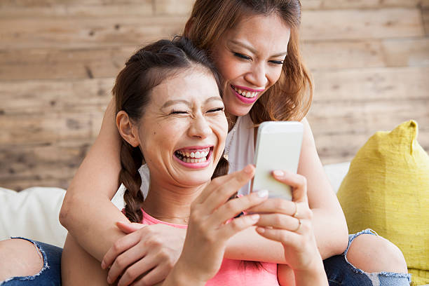istock Two smiling young female friends reading text message 485487620
