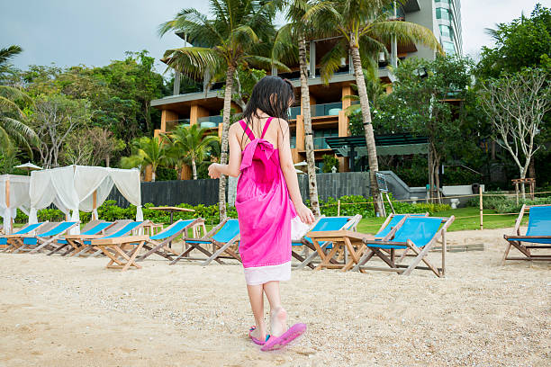 kid in pink walking on the beach stock photo