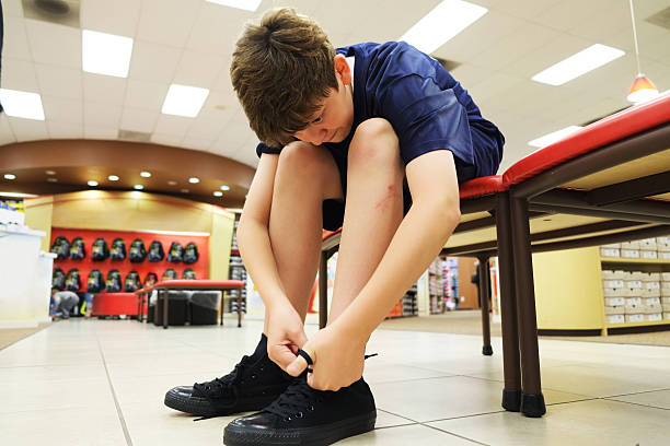 Young boy trying sports shoes in a store