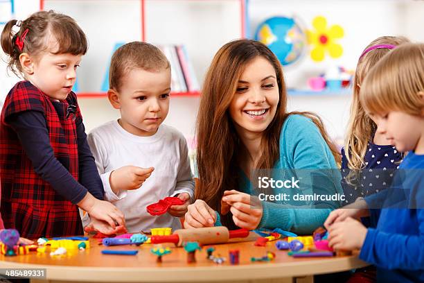 Nursery Teacher Playing With The Kids Stock Photo - Download Image Now - 12-17 Months, 4-5 Years, A Helping Hand