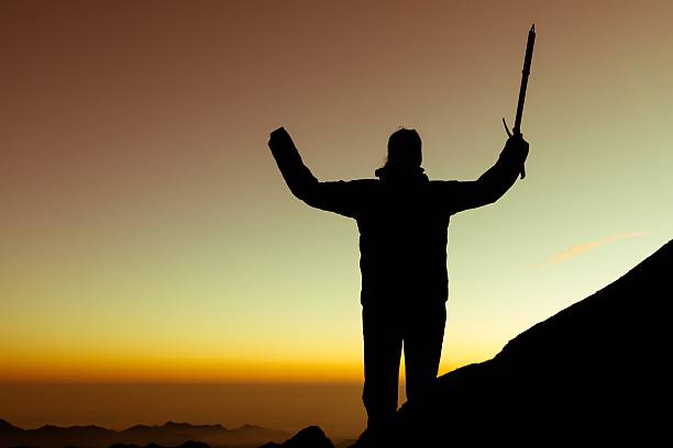 Silhouette of alpinist celebrating. stock photo