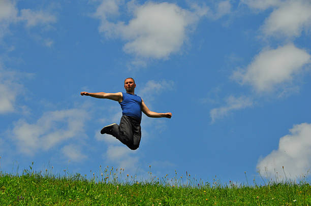 istock Beautiful man jumps high on grass 485491734