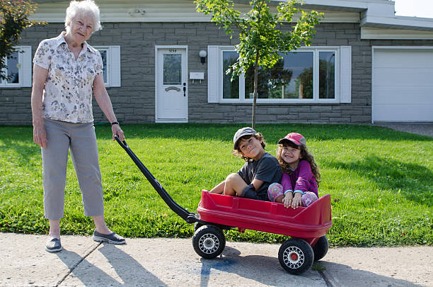 A little boy sitting in a red wagon.