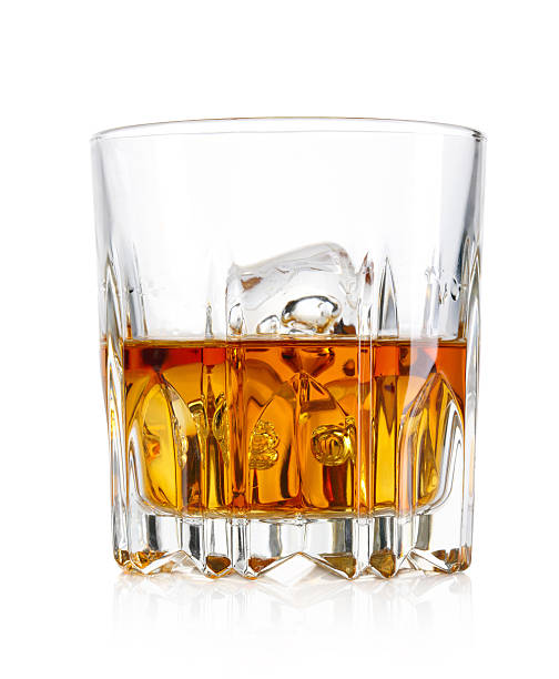 Glass of whiskey and ice isolated on white background stock photo