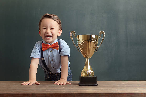 istock Little boy smiling with a golden trophy 485498254