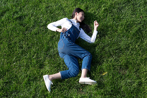 healthy beautiful girl, lying on the lawn, do the movements demo