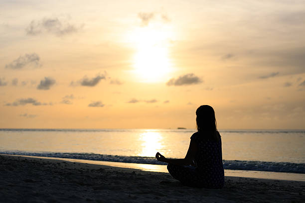 istock Woman meditation on sunset beach 485500310