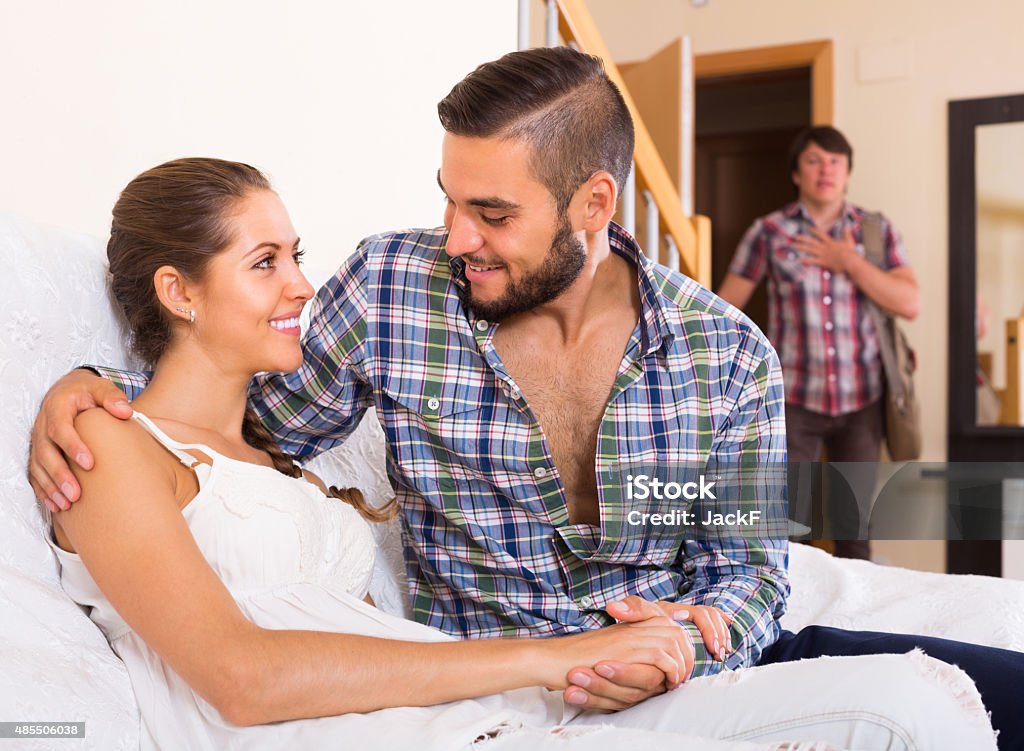 Adult and cheating partner at home Surprised adult discovering his cheating attractive young wife at home 2015 Stock Photo