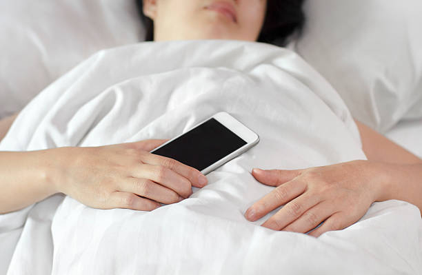 istock Woman sleeping in bed and holding a mobile phone. 485507012