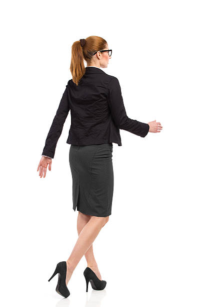 пешие прогулки женщина, задний угол вид. - women businesswoman elegance skirt стоковые фото и изображения