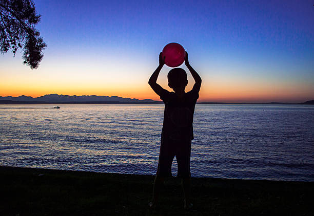 istock Silhouette of a boy with a red ball. 485509323