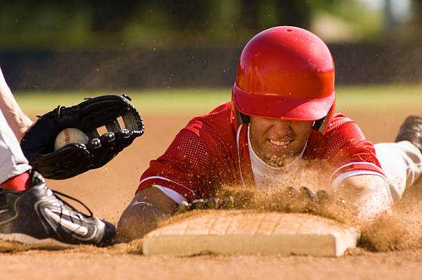 Baseball Player Sliding Into Base Baseball Player Sliding Into Base base sports equipment photos stock pictures, royalty-free photos & images