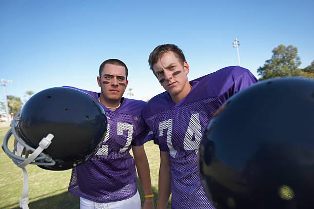 istock Two Football Players Holding Helmets 485509687