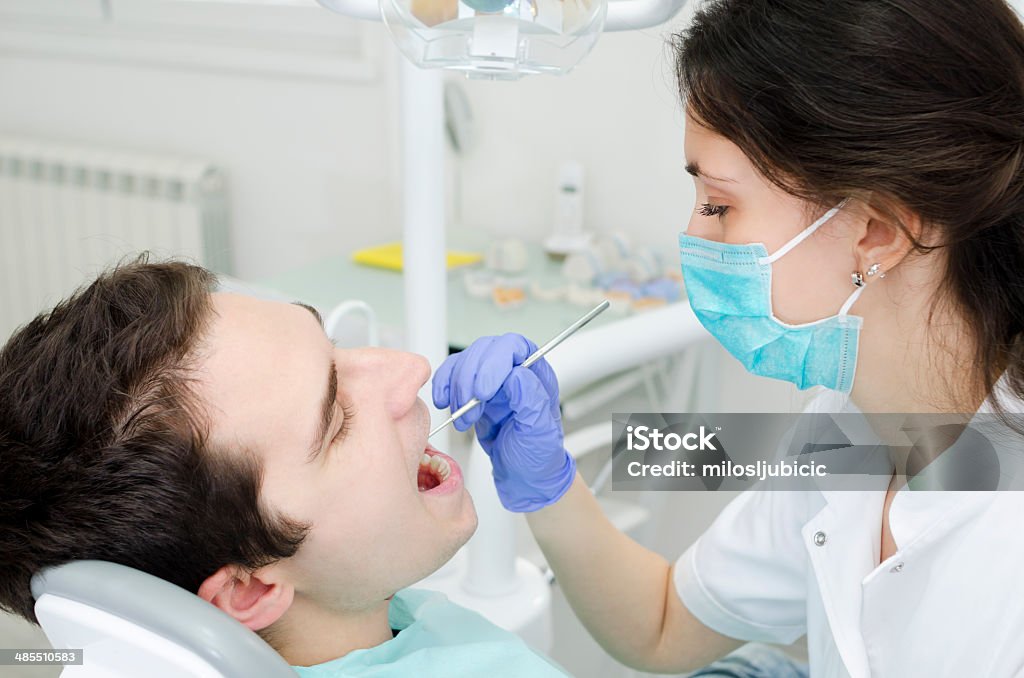 Dental Young male with open mouth during oral checkup at the dentist Adult Stock Photo