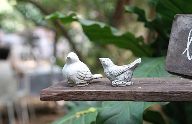 Two Birds sculpture on the timber plank with nature background