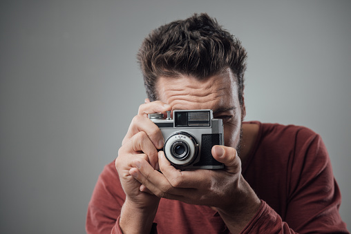 Young man taking pictures with an old vintage camera