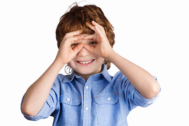 istock Handsome smiling boy makes aviator glasses with his hands. Isolated 485512324