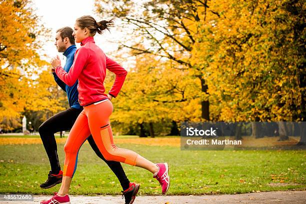Couple Jogging In Autumn Nature Stock Photo - Download Image Now - Couple - Relationship, Running, Profile View