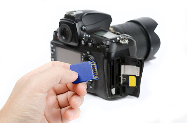 istock Hand holds SD Memory card and DSLR camera on background 485516100