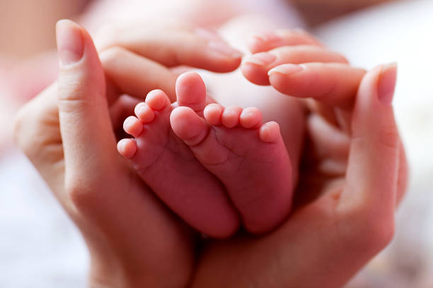 istock Baby feet cupped into mothers hands 485517596