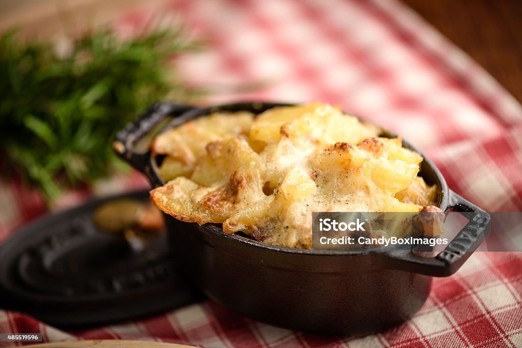 Potato gratin dauphinois Potato gratin dauphinois in traditional french ceramic pan on rustic tablecloth 2015 Stock Photo
