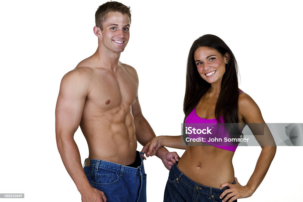Dieting couple Man and woman wearing oversized jeans for a weight loss concept  20-24 Years Stock Photo