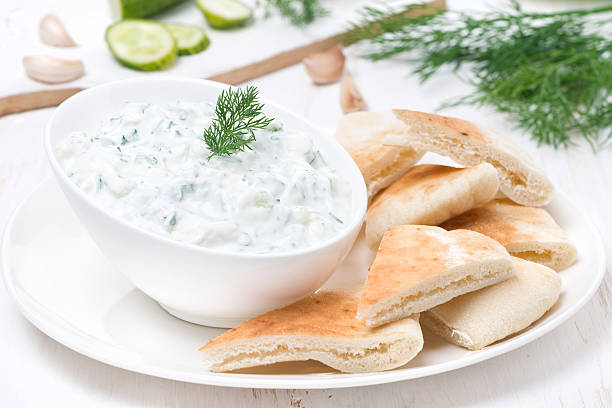 yoghurt sauce tzatziki with pieces of pita bread yoghurt sauce tzatziki with pieces of pita bread, close-up tzatziki stock pictures, royalty-free photos & images