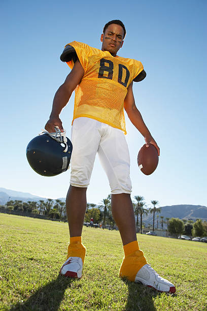 istock Football Player Holding Helmet and Ball 485524727